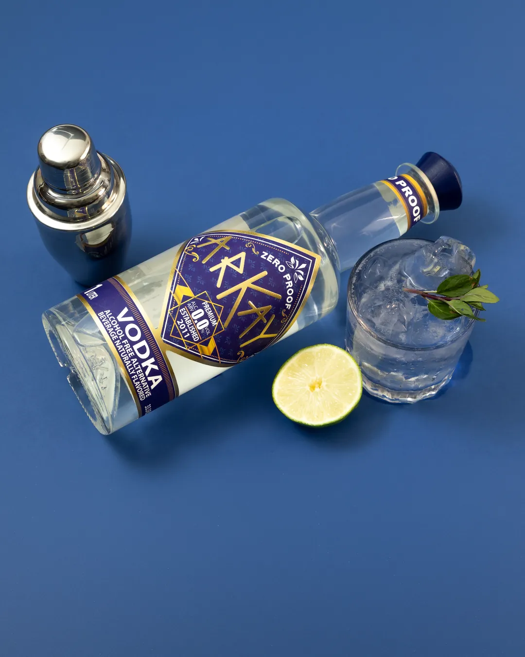 ARKAY vodka alternative with lime and a zero-proof mocktail on a blue background